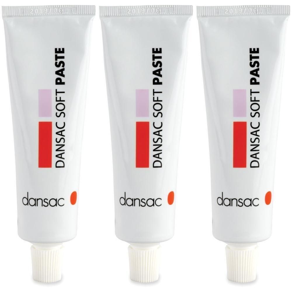 Tre tubi di Dansac Soft Paste con design a rettangolo rosso e rosa e tappo a vite bianco.