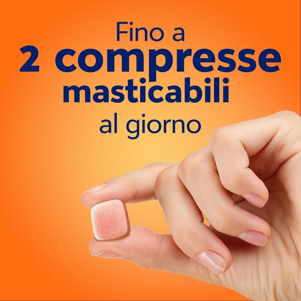 Una mano tiene una compressa masticabile Cebion gusto arancia. Fino a 2 compresse masticabili al giorno.