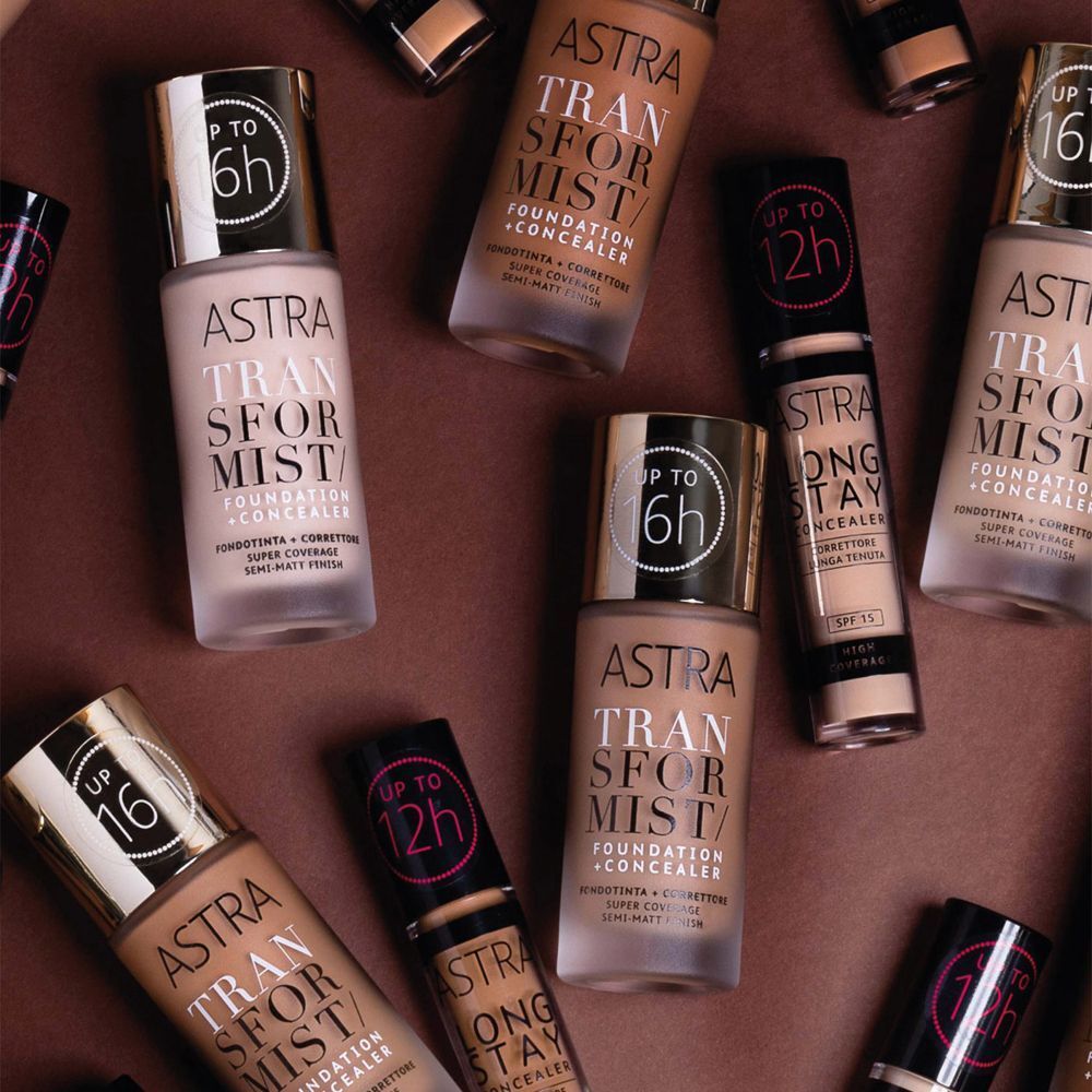 Astra Transformist Foundation + Concealer in varie tonalità di pelle. Flaconi con tappi argentati, alcuni con indicazione "fino a 6h" o "fino a 16h".