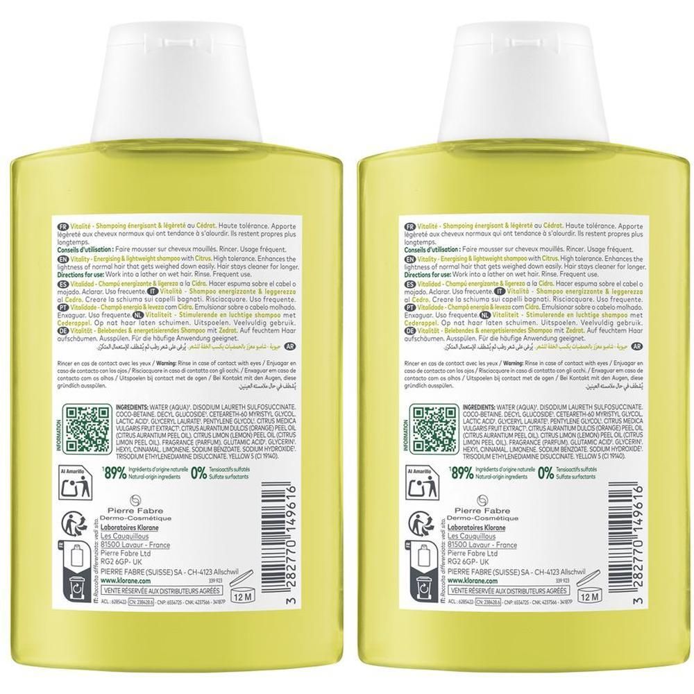 Due flaconi gialli di shampoo con tappi bianchi. Etichette posteriori con ingredienti e istruzioni.