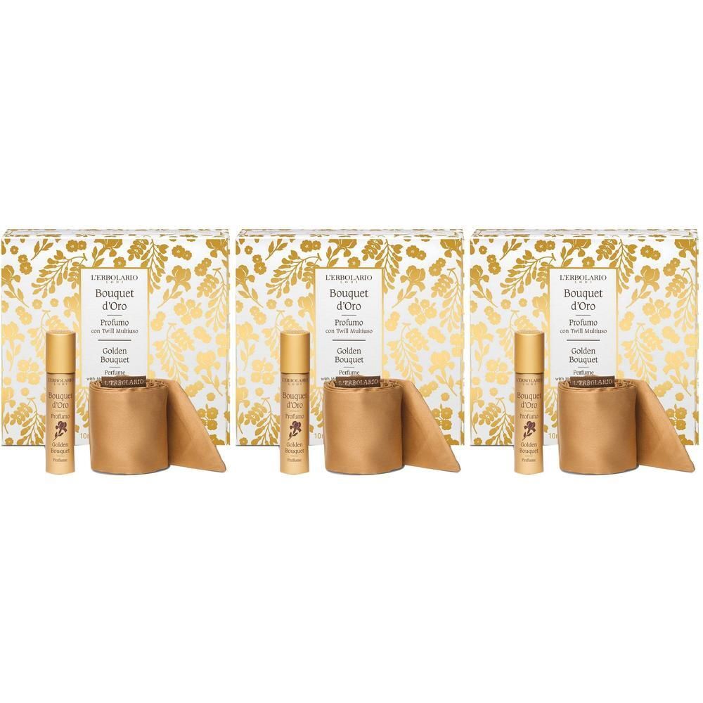 Tre set con una bottiglia di profumo dorata e un diffusore di fragranza in una scatola regalo con motivo dorato.