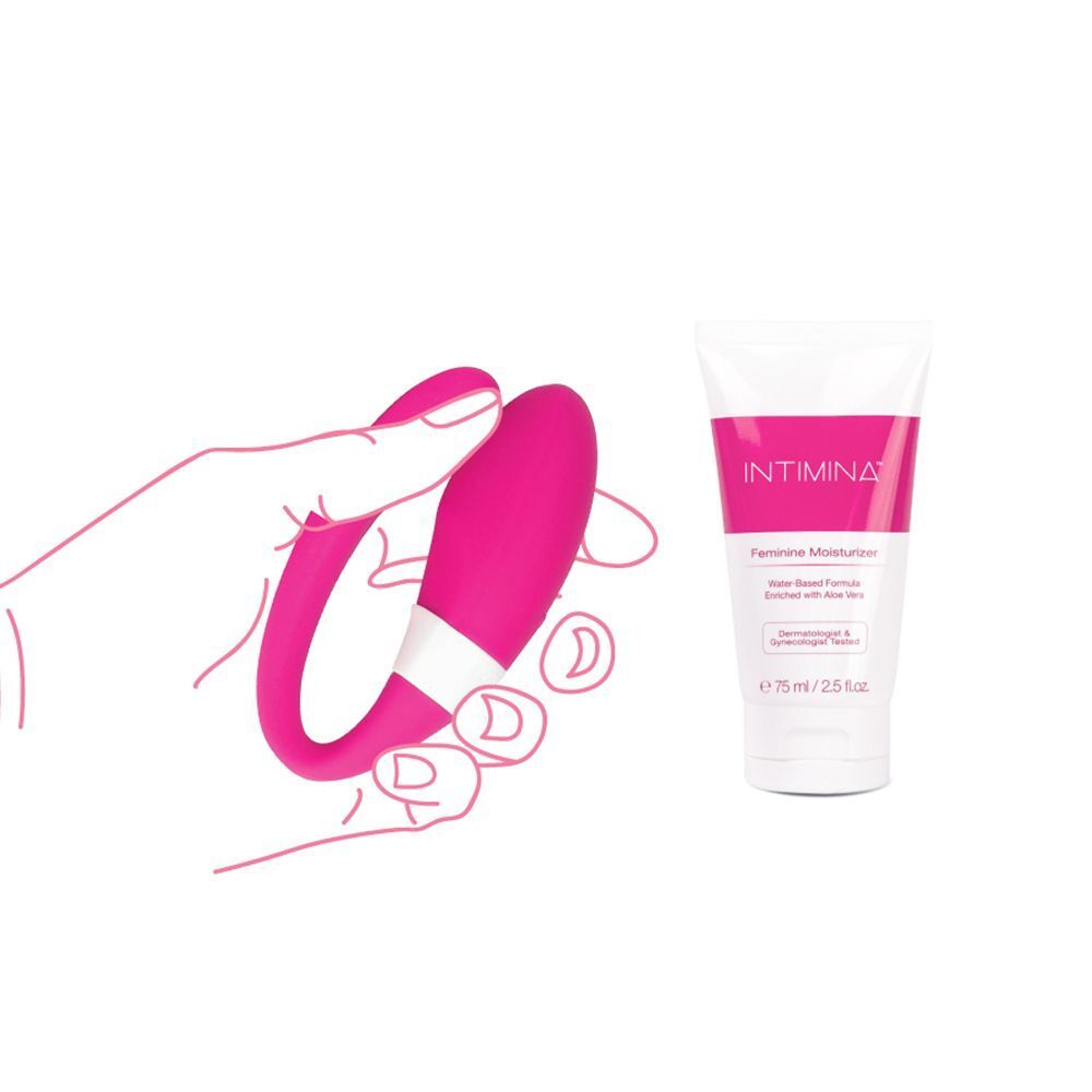 Una mano tiene un vibratore per coppie rosa. Accanto, un tubetto di Intimina Feminin Moisturizer.