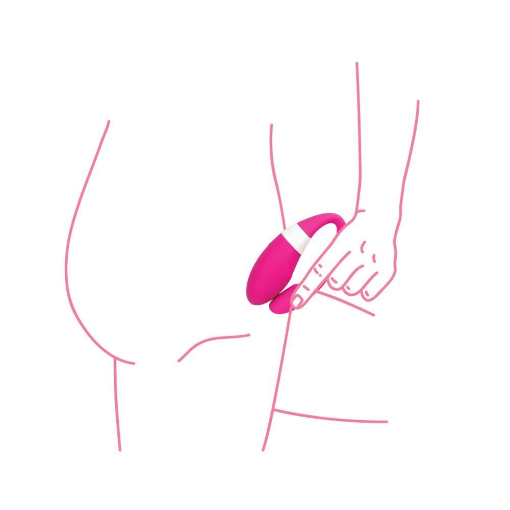 Una mano tiene un vibratore per coppie rosa sul fianco di una persona.