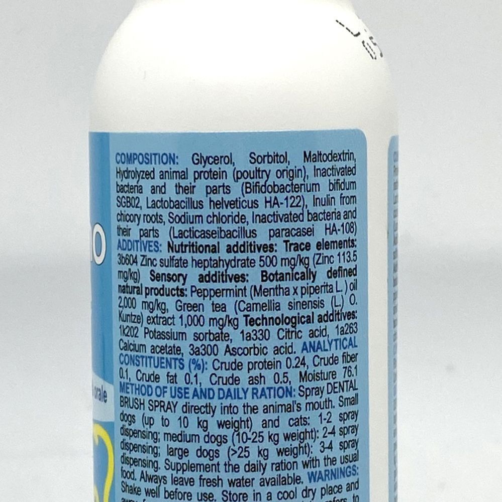 Cane e gatto seduti su una valigia accanto a una bottiglia spray.