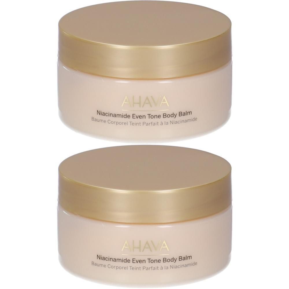 Due vasetti di balsamo corpo Ahava Niacinamide Even Tone con tappi dorati.