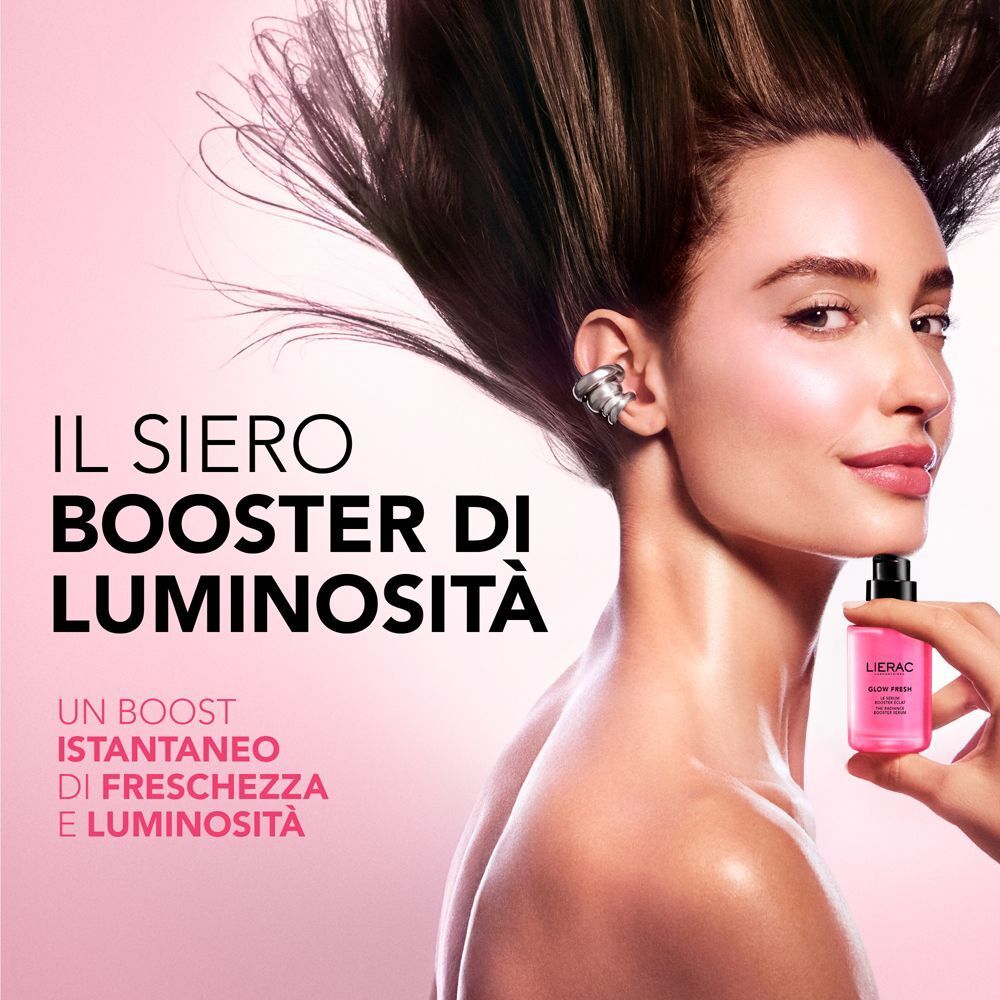 Donna con capelli sciolti tiene in mano un flacone Lierac Glow Fresh.