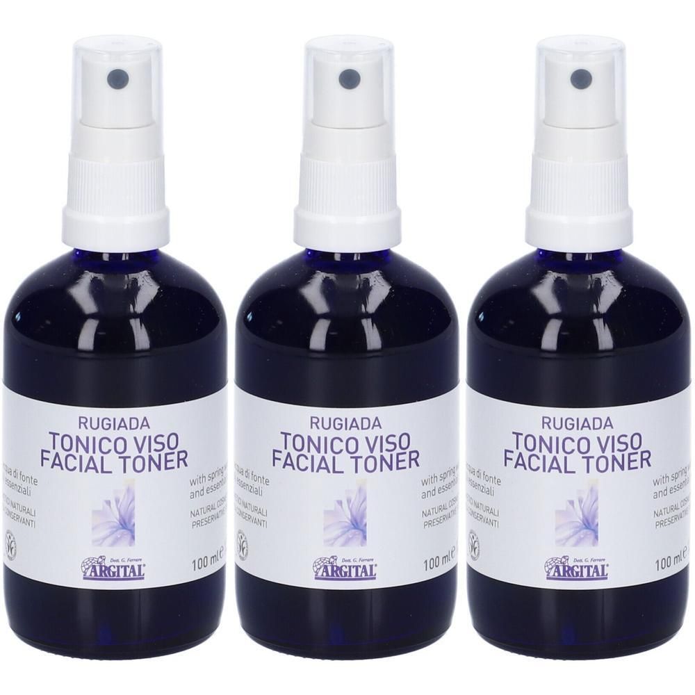 Tre flaconi di Rugiada Facial Toner con erogatore spray. Flaconi in vetro blu scuro con etichette bianche e fiore blu.