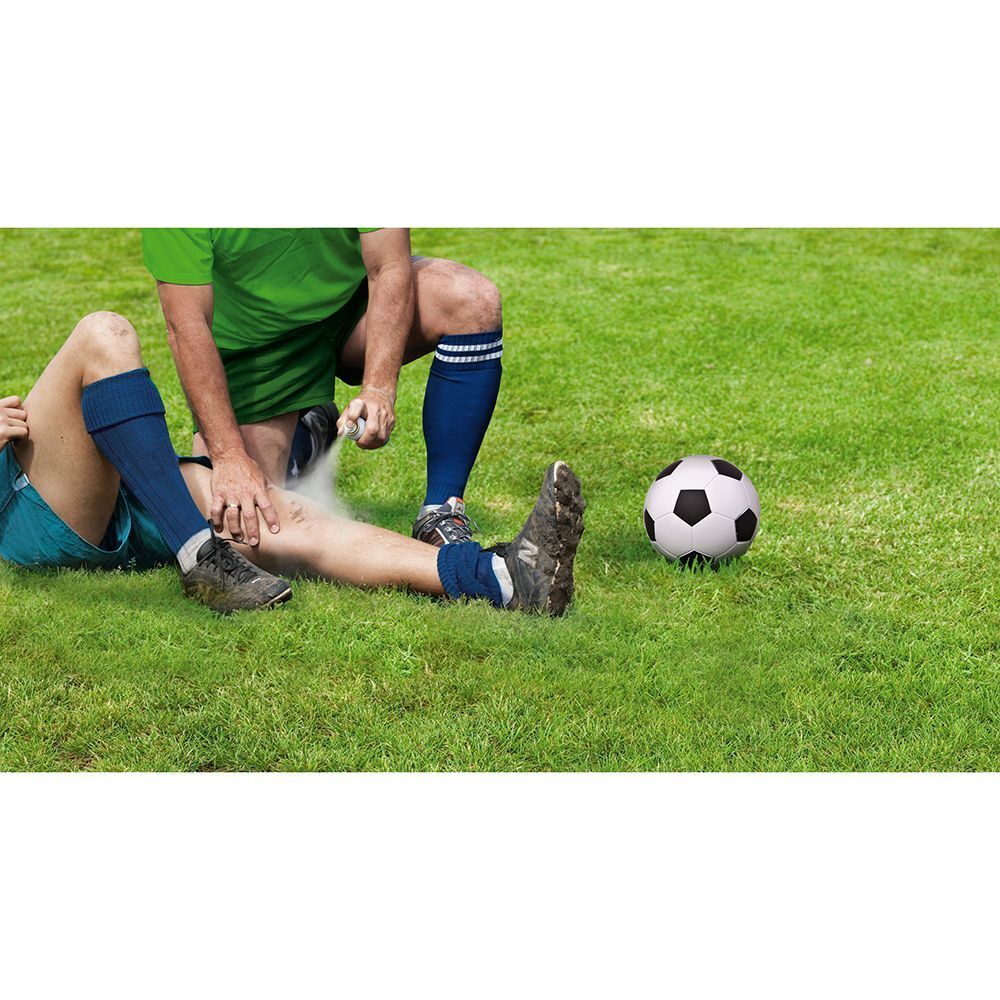 Un calciatore sull'erba viene trattato da un soccorritore con uno spray.