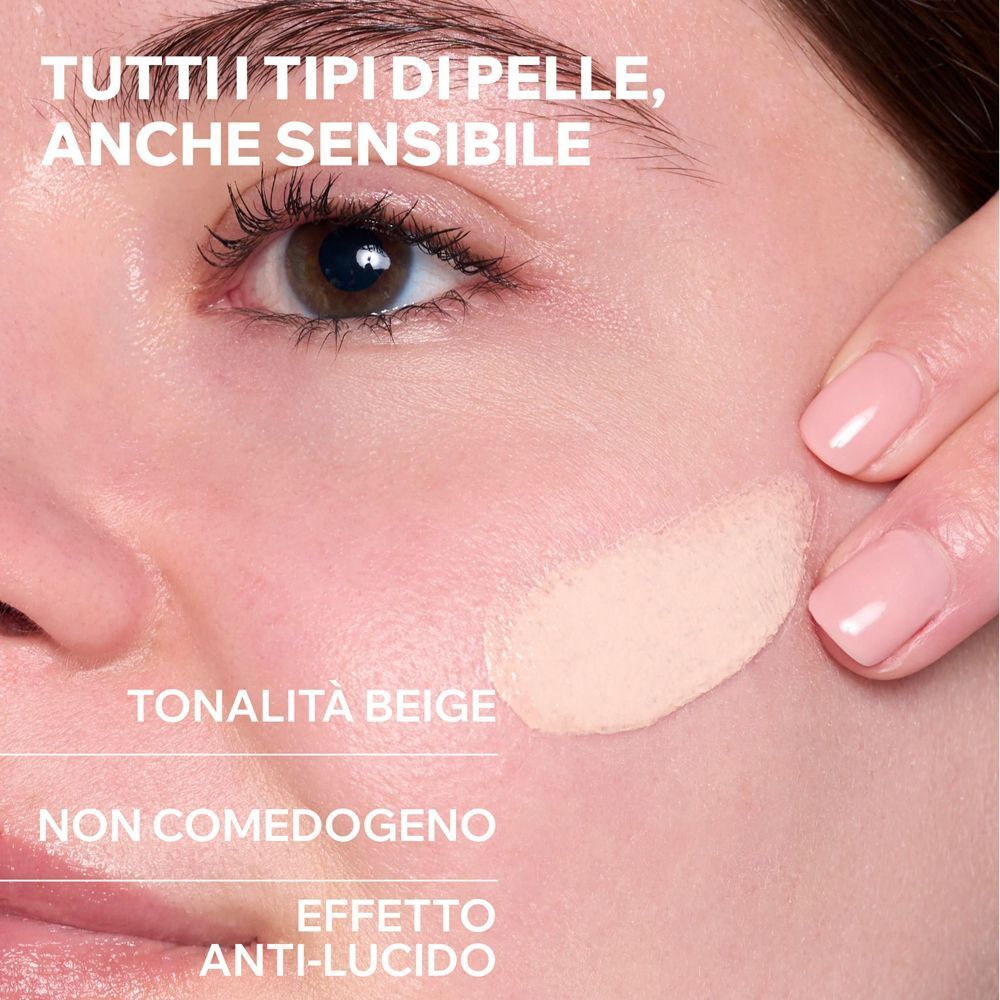 Primo piano di una pelle con crema colorata chiara applicata, con testo.