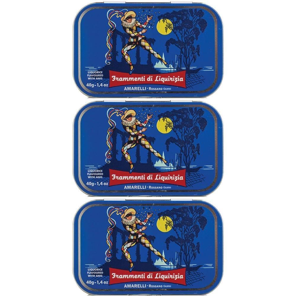 Tre scatole blu in latta con disegno liquirizia: figura di arlecchino davanti a luna e alberi.