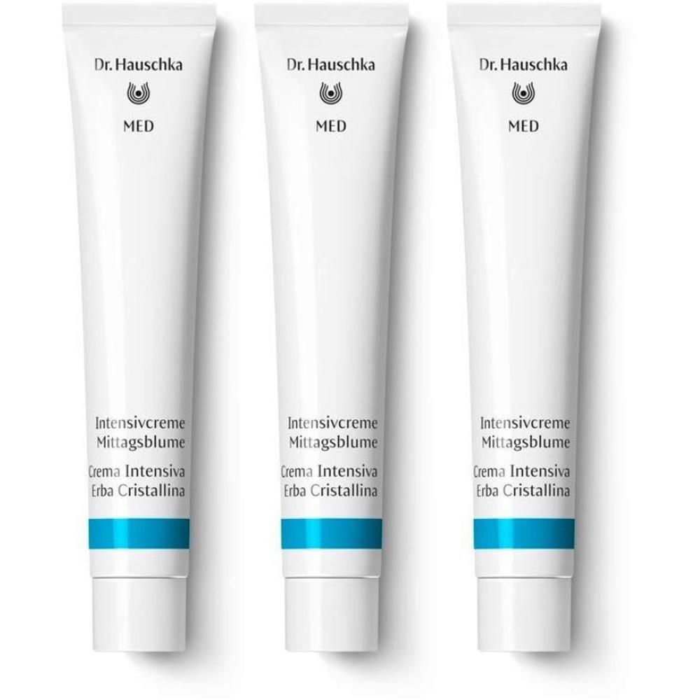 Tre tubetti bianchi Dr. Hauschka Crema Intensiva Erba Cristallina con banda blu.