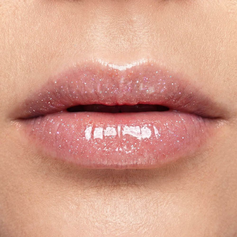 Primo piano di labbra con lucidalabbra rosa brillante e glitter.