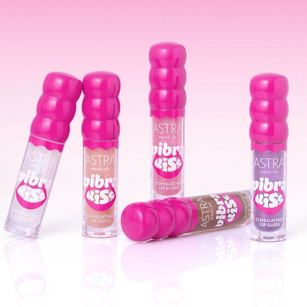 Cinque flaconi di gloss labbra Astra con tappi rosa a coste. Visibili colori e texture diverse.