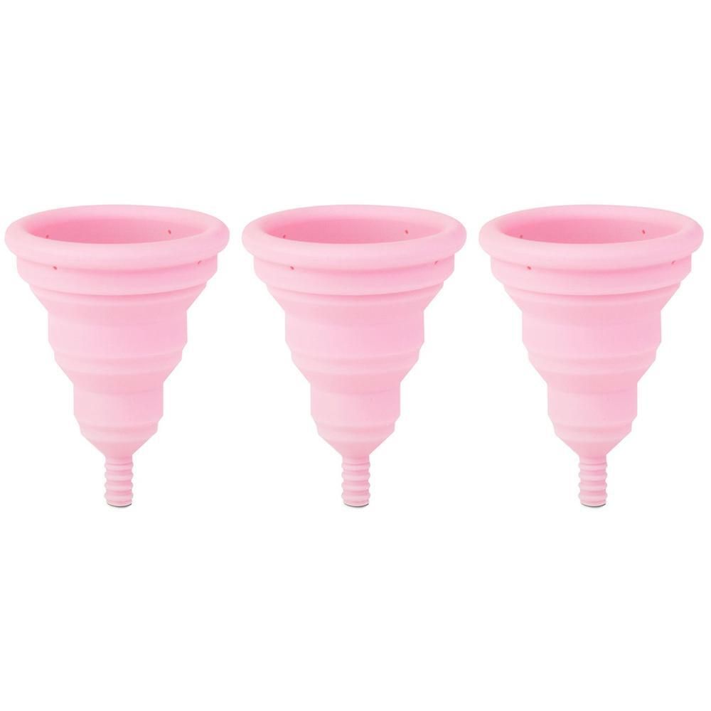 Tre coppette mestruali pieghevoli rosa una accanto all'altra.
