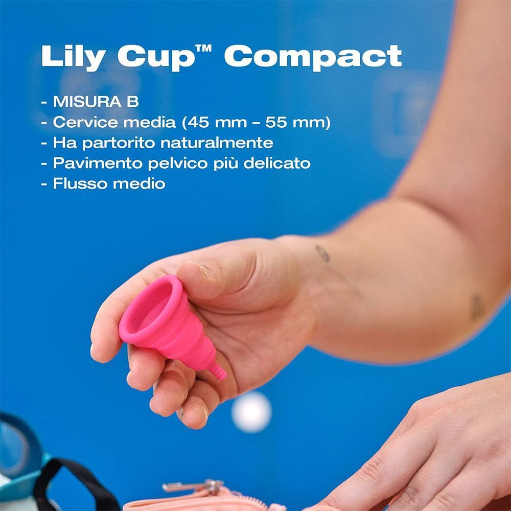 Una mano tiene una piccola coppetta mestruale pieghevole rosa.
