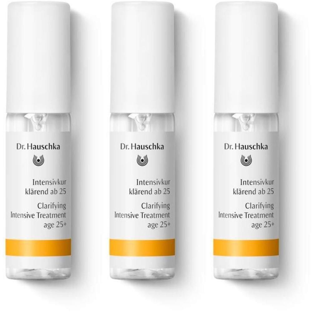 Tre flaconcini Dr. Hauschka Trattamento Intensivo Purificante Da 25 Anni con erogatore bianco e banda arancione.