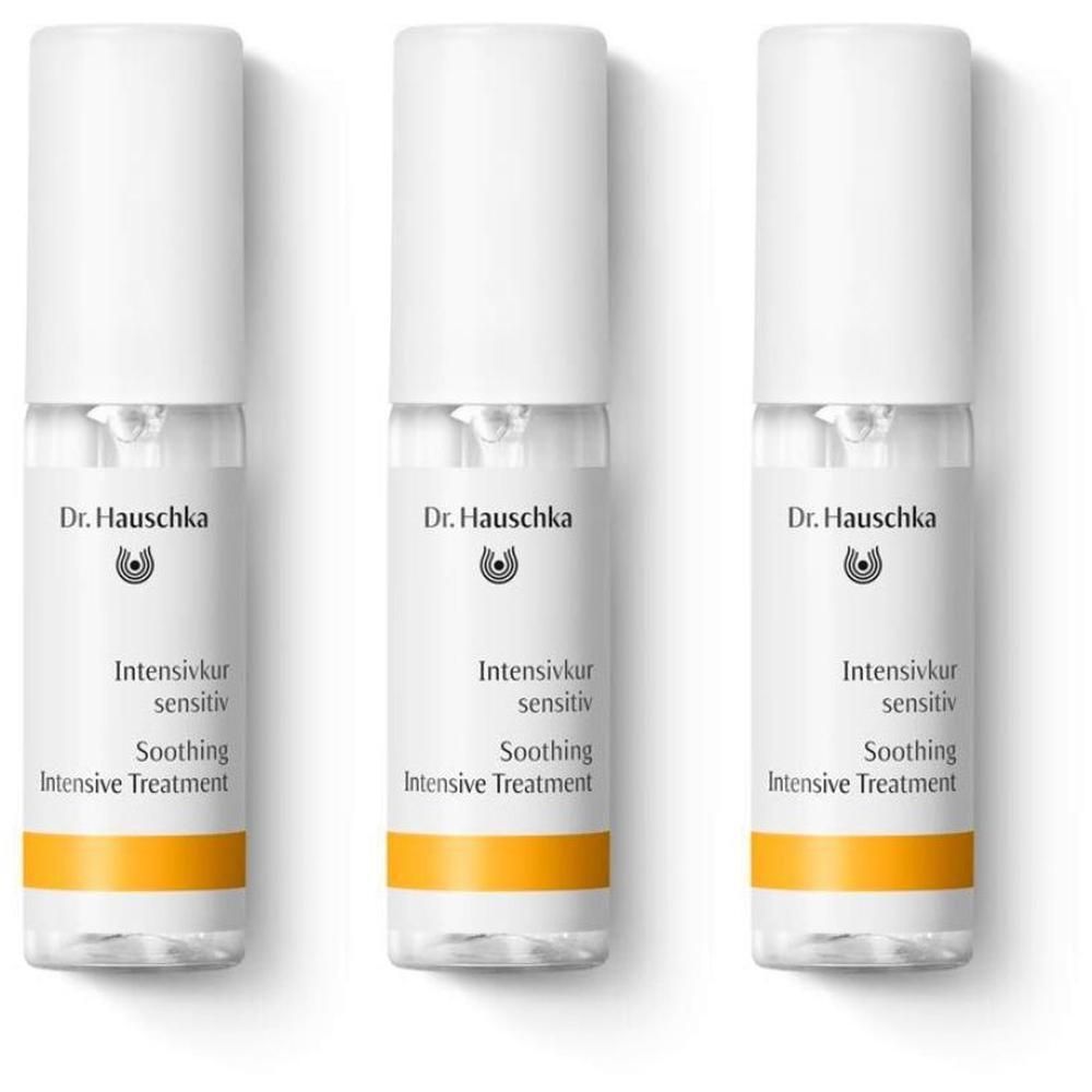Tre flaconcini Dr. Hauschka Trattamento Intensivo Pelle Sensibile con tappo bianco e banda arancione.
