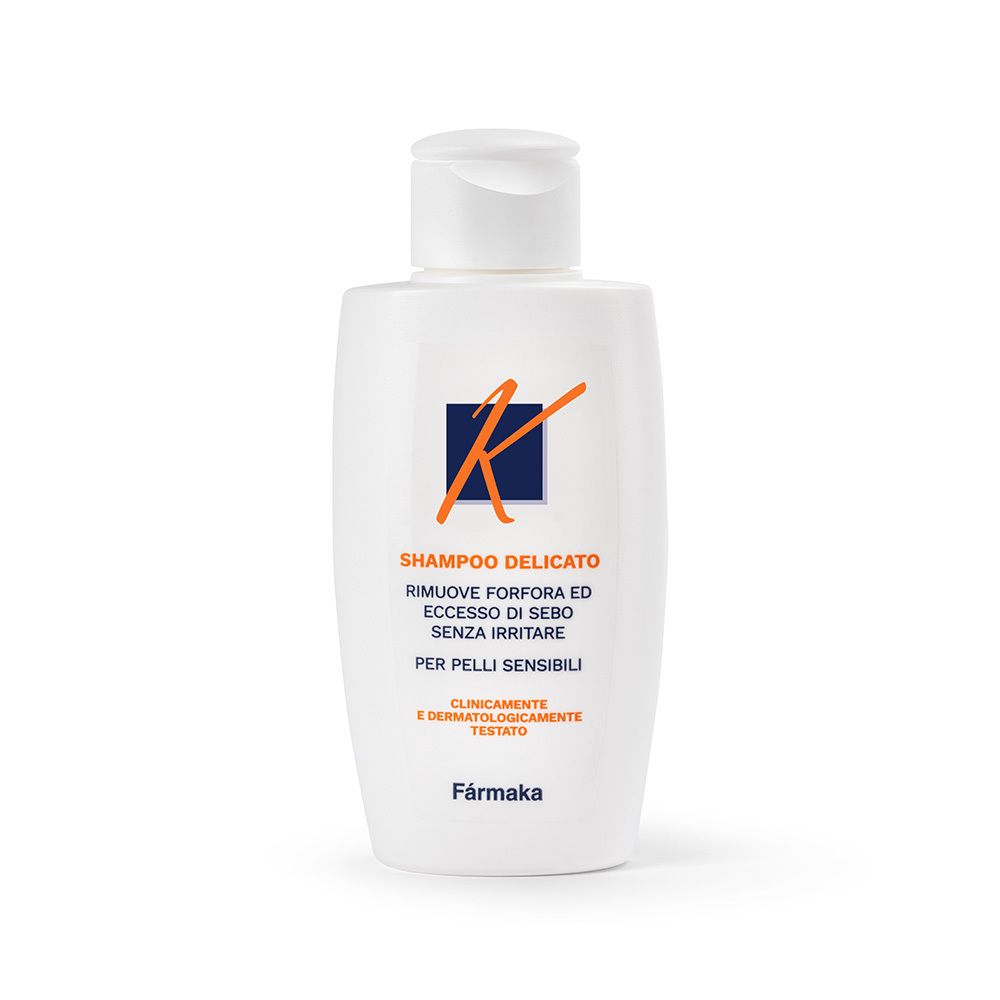 Flacone di shampoo bianco con logo Kouriles e testo. Scritta: Shampoo delicato, per pelli sensibili.