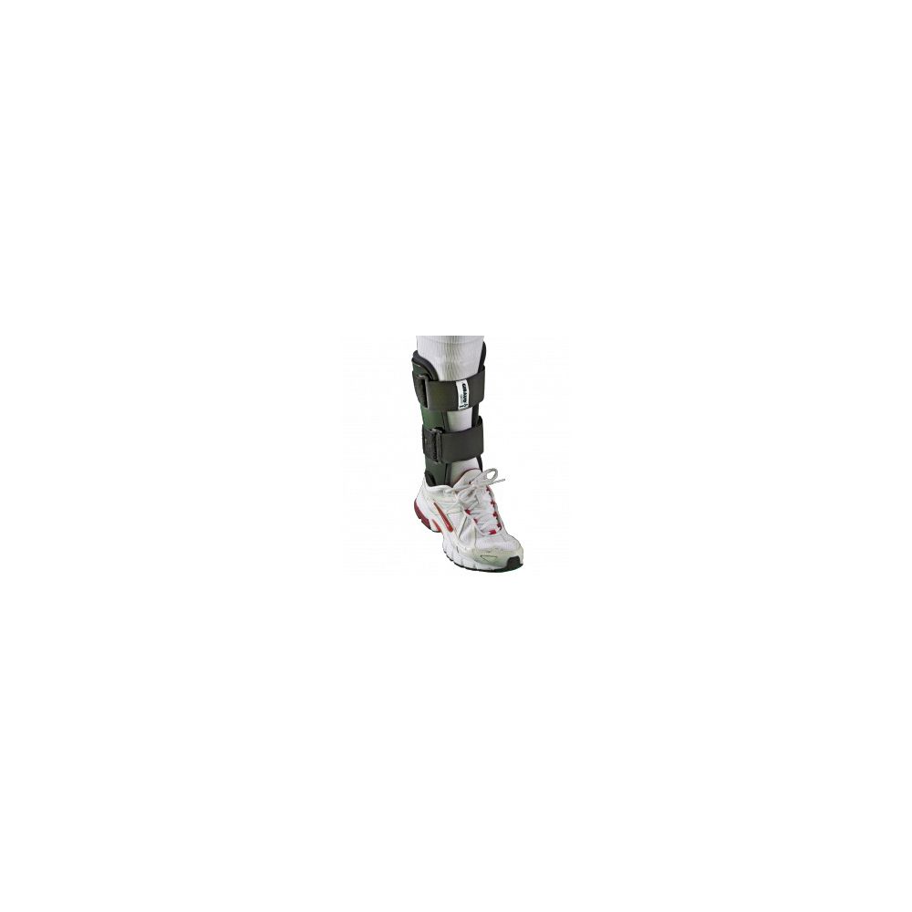 Tutore caviglia su gamba. Tutore nero-grigio con chiusure a strappo. Piede in scarpa sportiva.