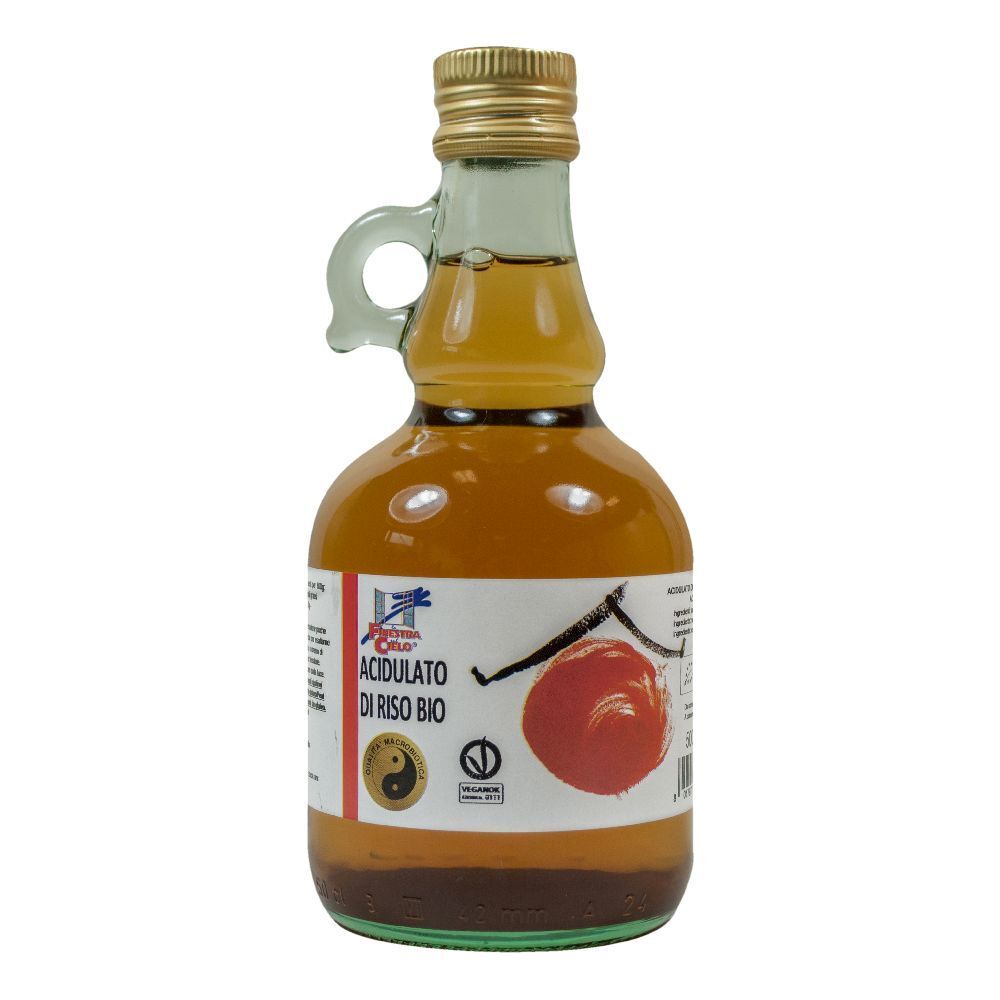 Bottiglia di vetro con tappo dorato e manico. Etichetta con nome del prodotto e logo.