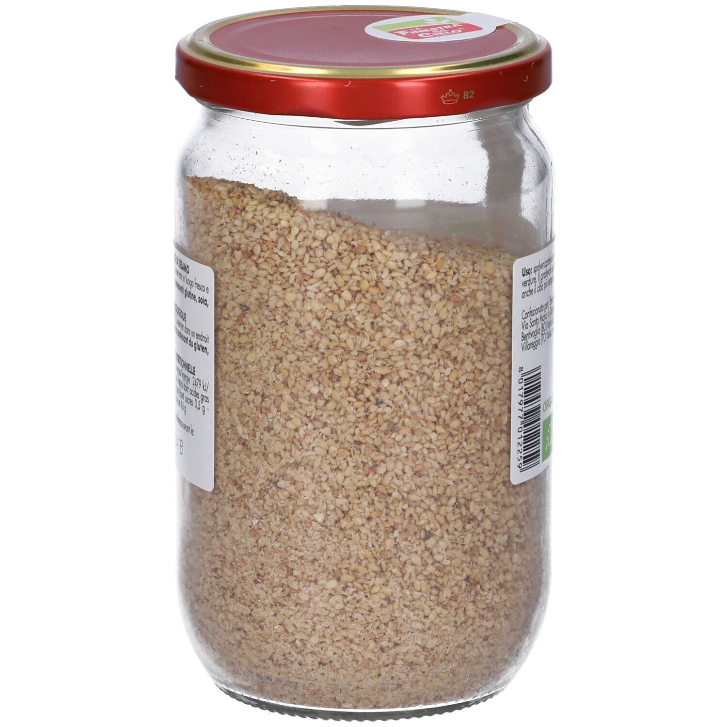 Vasetto di Gomasio Bio. Vista laterale. Coperchio rosso. Contenuto granulare. Etichetta con testo.