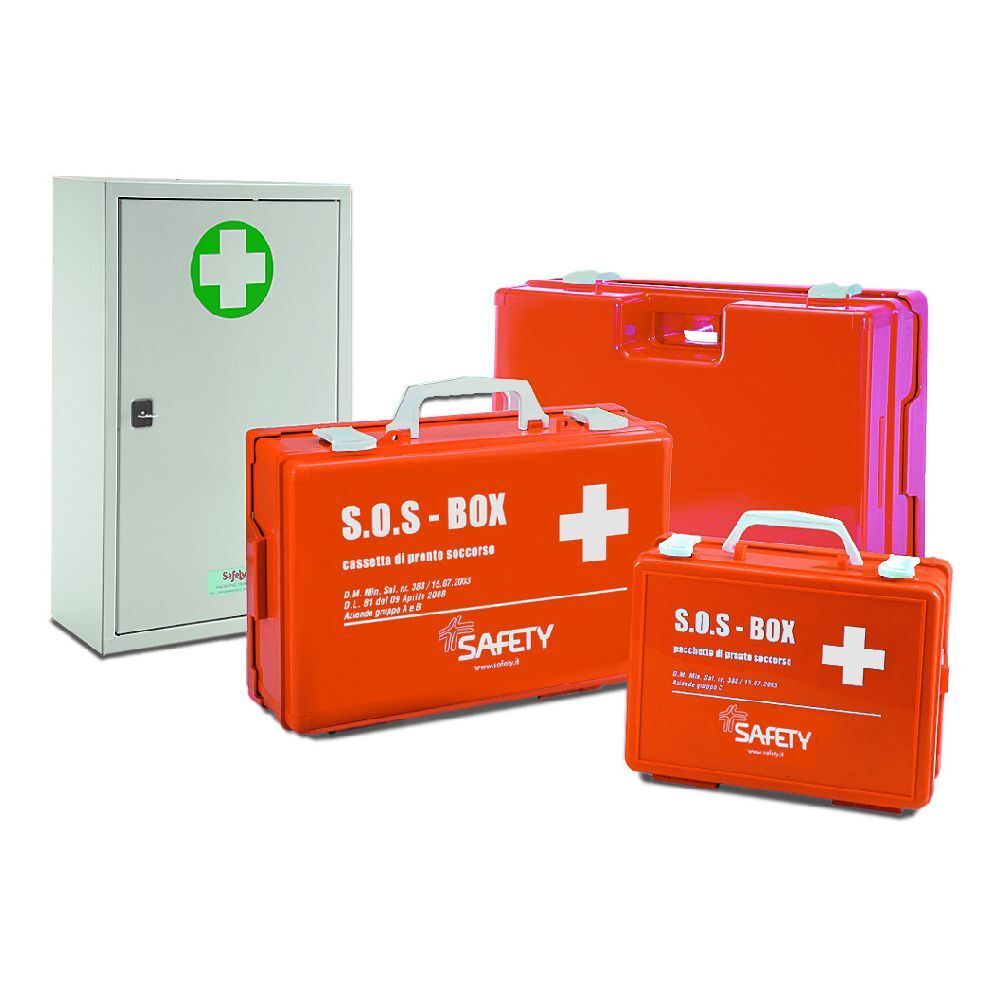 Più cassette di pronto soccorso arancioni e un armadio con croce verde. Valigie con manici e croce bianca. Scritta S.O.S.-BOX.
