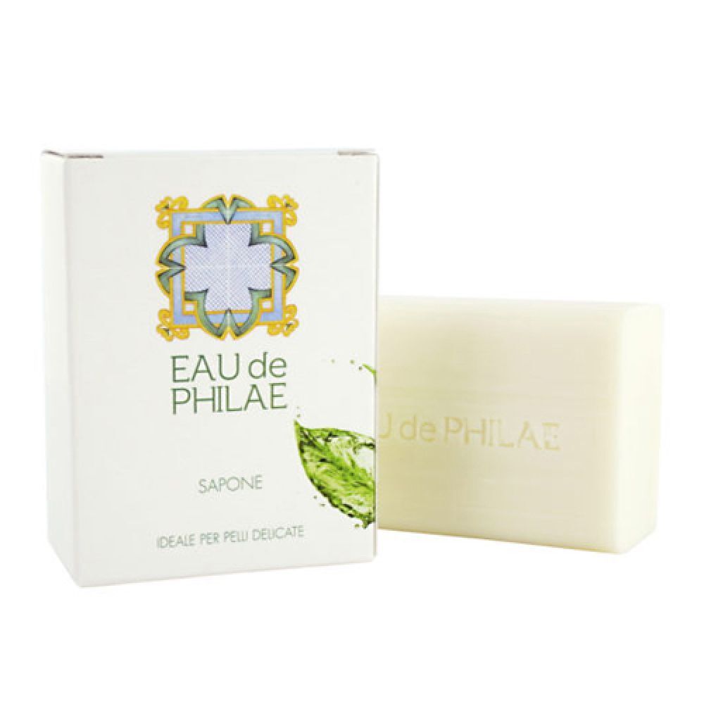 EAU de PHILAE Seife mit Verpackung. Rechteckige, helle Seife mit geprägtem Schriftzug. Weiße Kartonverpackung mit floralem Muster und Schriftzug.