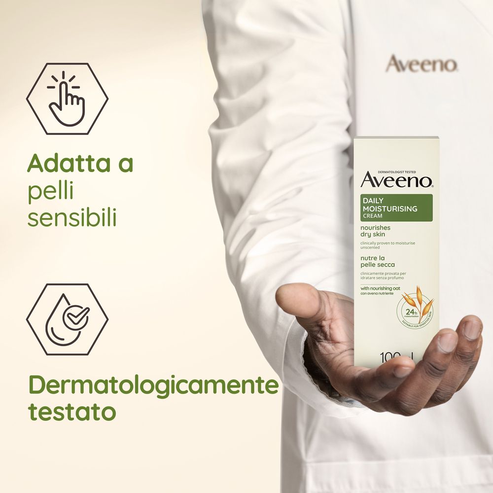 Main tenant l'emballage de Aveeno Daily Moisturising Cream. Texte : Adatta a pelli sensibili, Dermatologicamente testato.