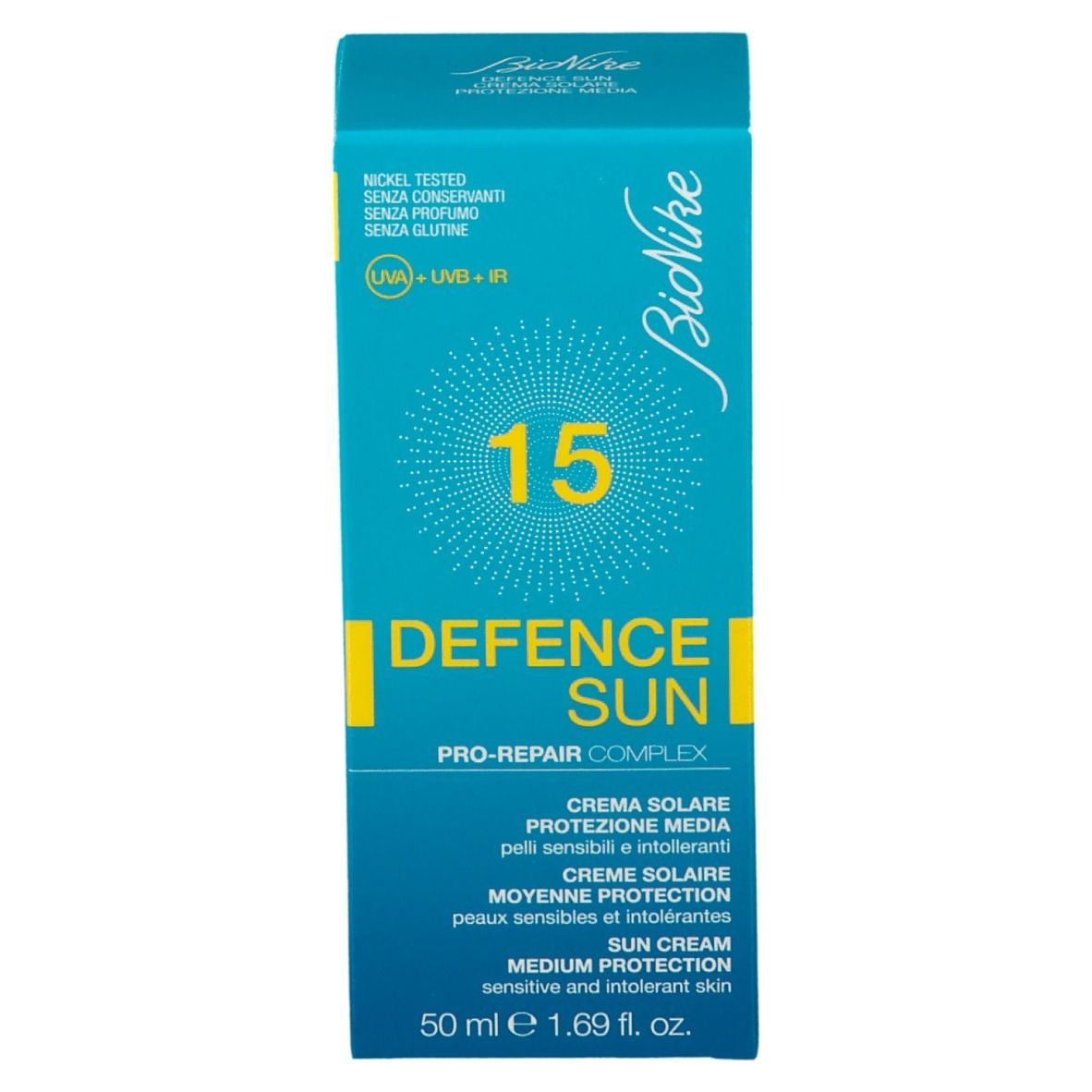 Boîte turquoise de crème solaire. Inscriptions: Bionike, 15, Defence Sun, UVA+UVB+IR. Testé au nickel, sans conservateurs, parfum ni gluten. 50 ml.