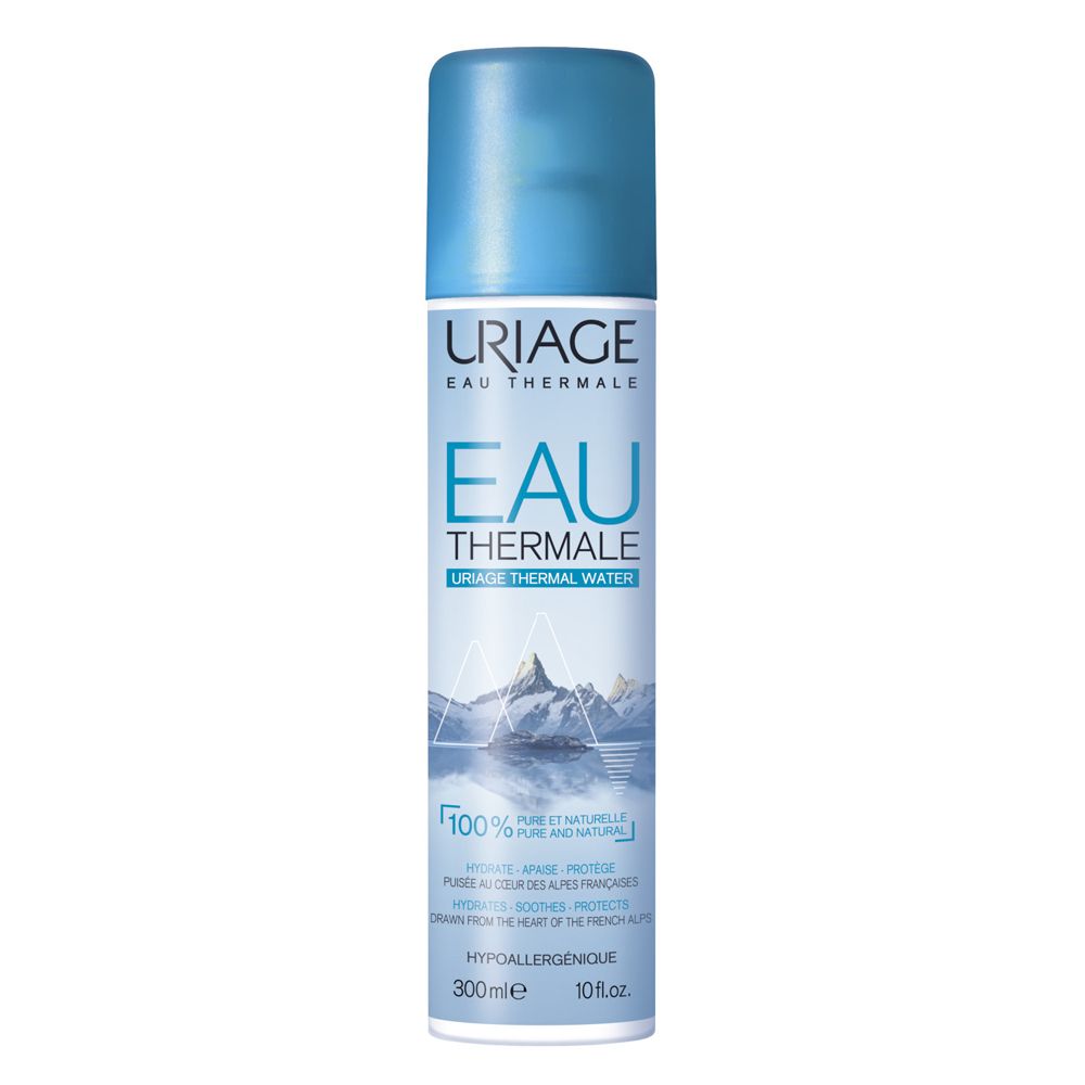 Spray Uriage Eau Thermale. Flacone spray blu con etichetta bianca. Montagne e testo. Ipoallergenico.
