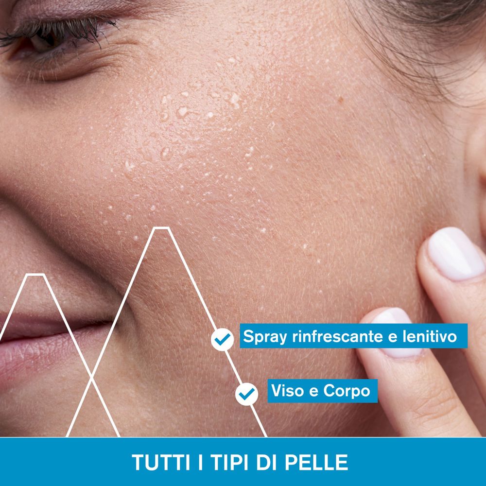 Primo piano di un viso con goccioline d'acqua. Testo: Tutti i tipi di pelle. Spray rinfrescante e lenitivo.