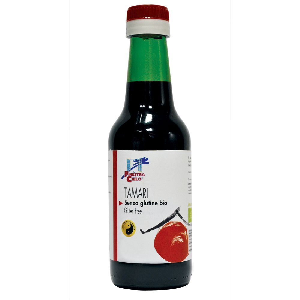 Liquido marrone in bottiglia di vetro. Tappo rosso e verde. Etichetta con nome del prodotto e logo.