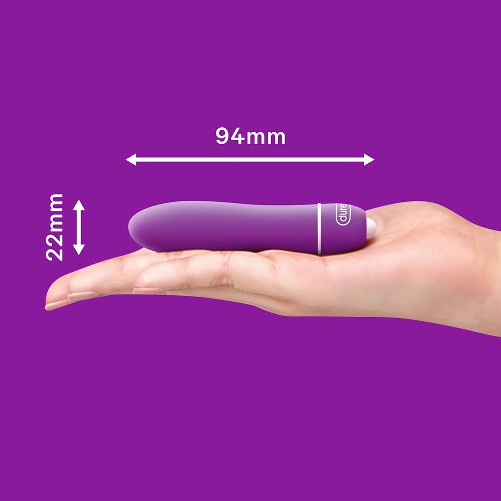 Ein lila Vibrator, der in einer Handfläche liegt, mit Maßen von 94 mm Länge und 22 mm Breite.
