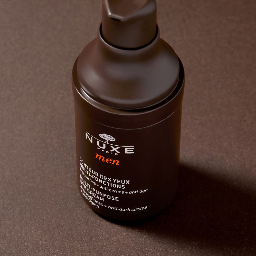 Flacone di crema occhi marrone con dosatore a pompa. Scritta: Nuxe Men, Contour des yeux multi-fonctions. Testo: anti-borse, occhiaie, anti-età.