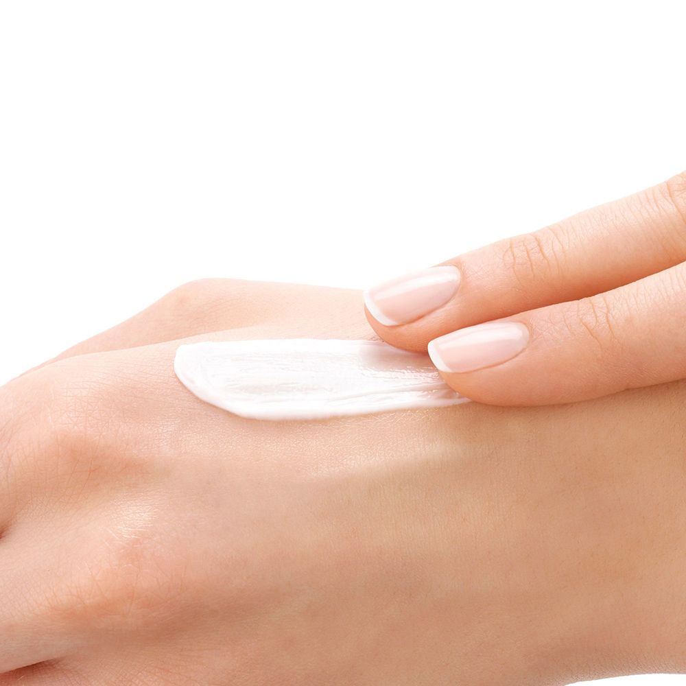 Hand mit Creme auf der Haut. Creme-Textur. Helle Haut.