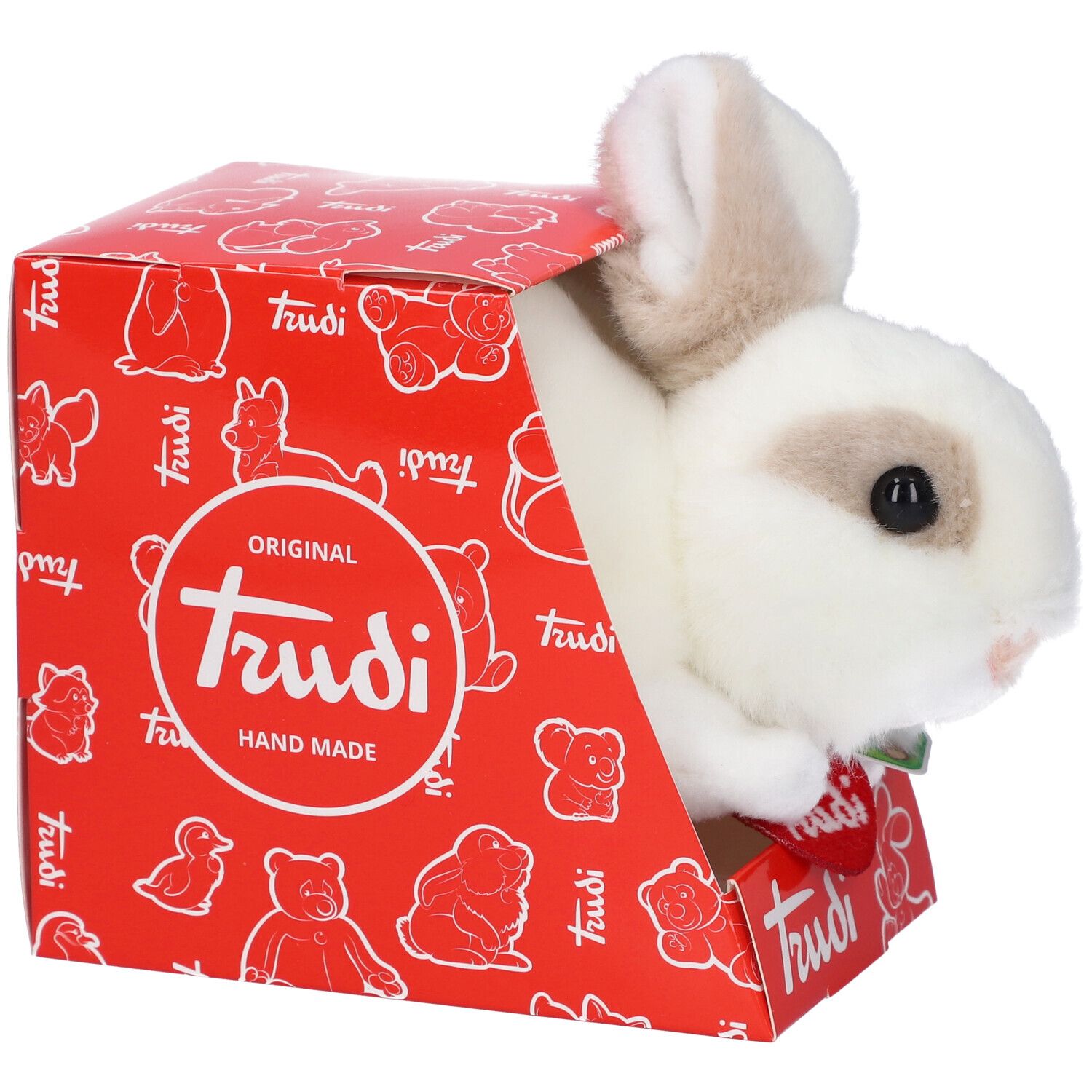 Coniglio di peluche bianco e marrone parzialmente fuori da una scatola rossa. C'è scritto "Trudi".