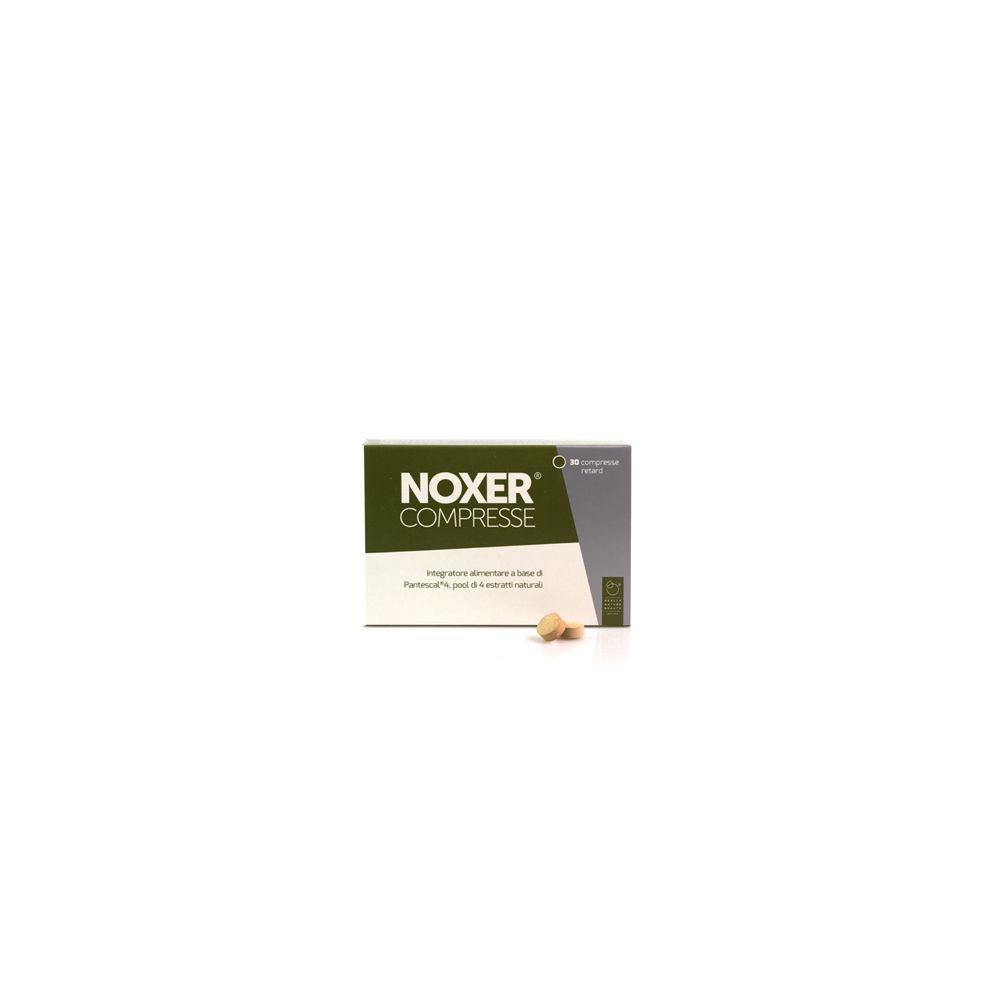 Scatola di compresse. Scritta: NOXER COMPRESSE. Alcune compresse sono visibili accanto.