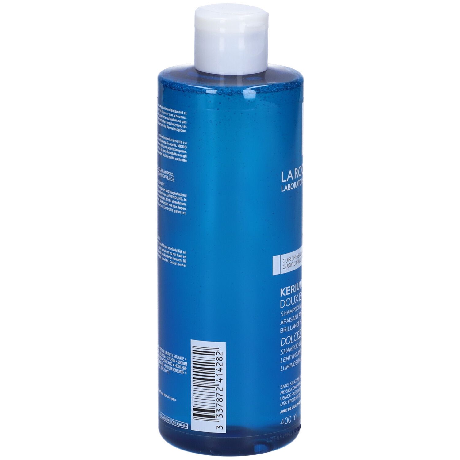 Retro di un flacone blu con tappo bianco. Testo: Kerium Doux Extreme, Shampooing-Gel Physiologique. Codice a barre e ingredienti.