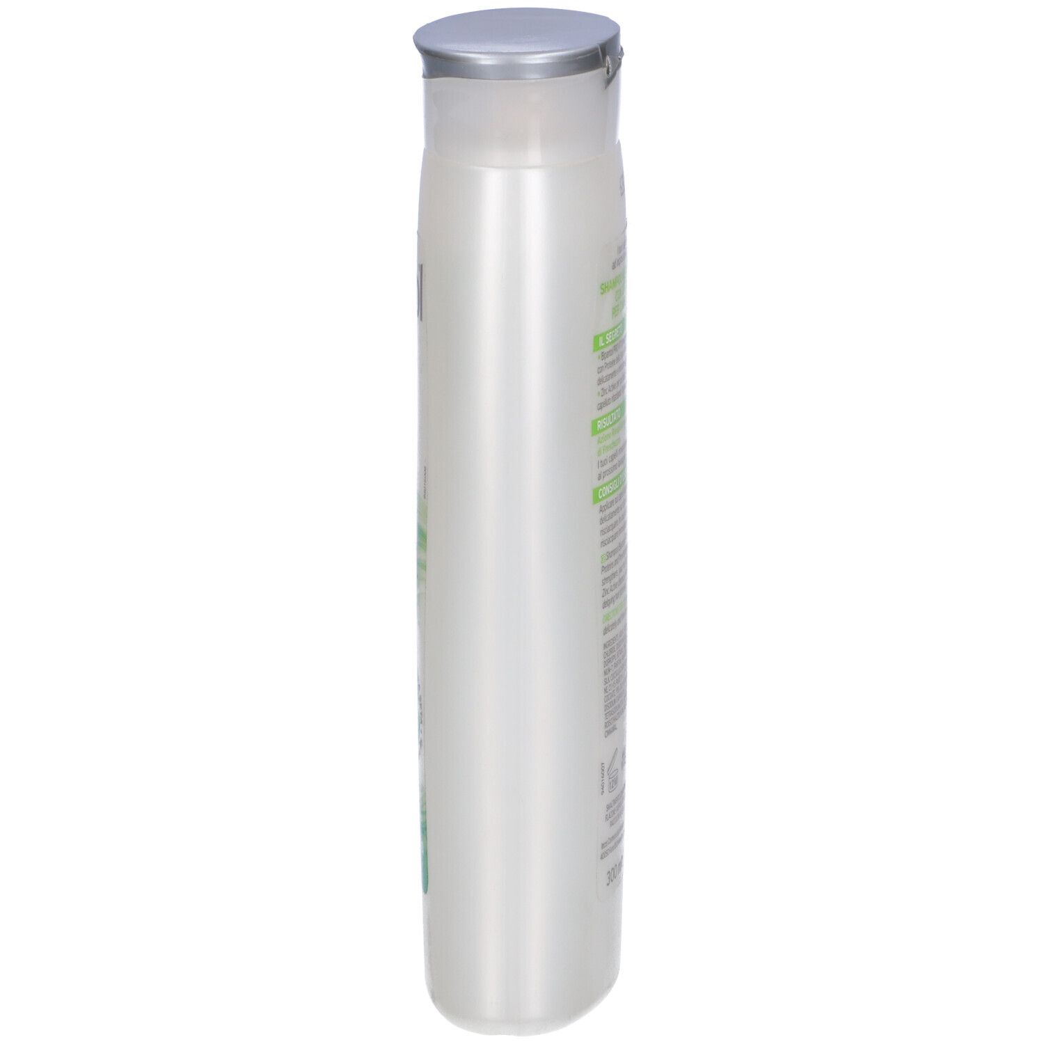 Flacone di shampoo, vista laterale. Bianco, con tappo argentato. Etichetta con testo.