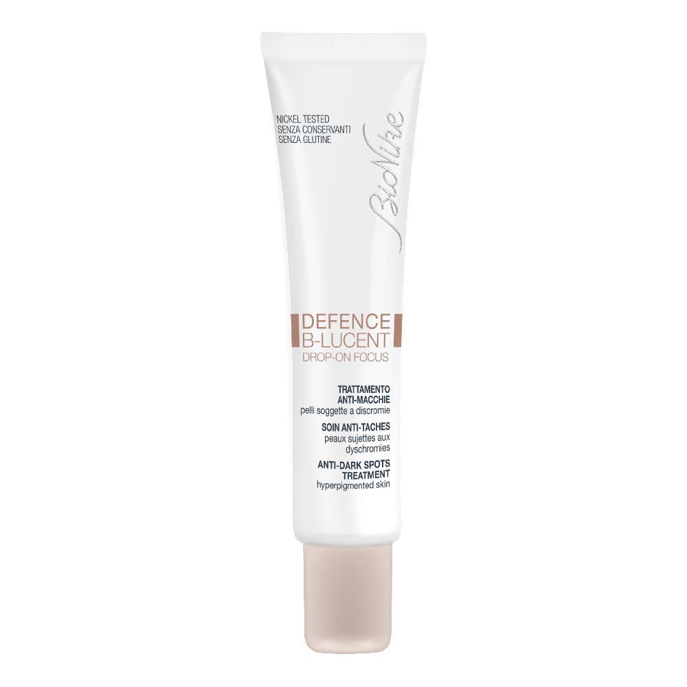 Tube blanc avec inscriptions marron et blanches. Nom du produit et marque visibles. Bouchon beige.