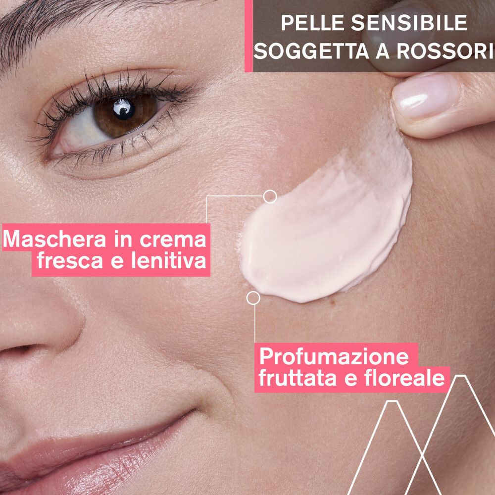 Nahaufnahme eines Gesichts. Creme wird aufgetragen. Text: Maschera in crema fresca e lenitiva. Profumazione fruttata e floreale.