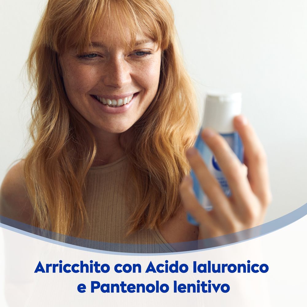 Donna che tiene in mano un flacone. Testo: Arricchito con Acido Ialuronico e Pantenolo lenitivo.