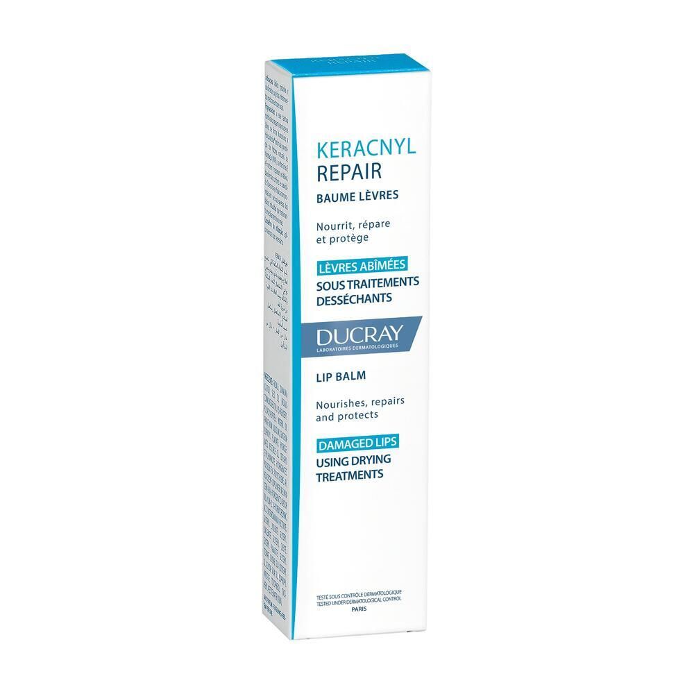 Kartonverpackung Ducray Keracnyl Repair Lippenbalsam. Weiß und blau. Text in mehreren Sprachen.