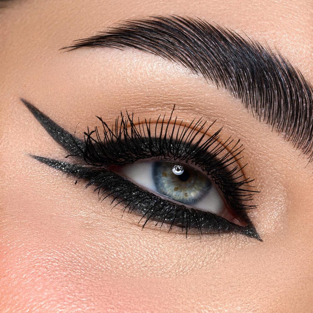Occhio con eyeliner nero glitterato. Primo piano dettagliato con ciglia e sopracciglio.
