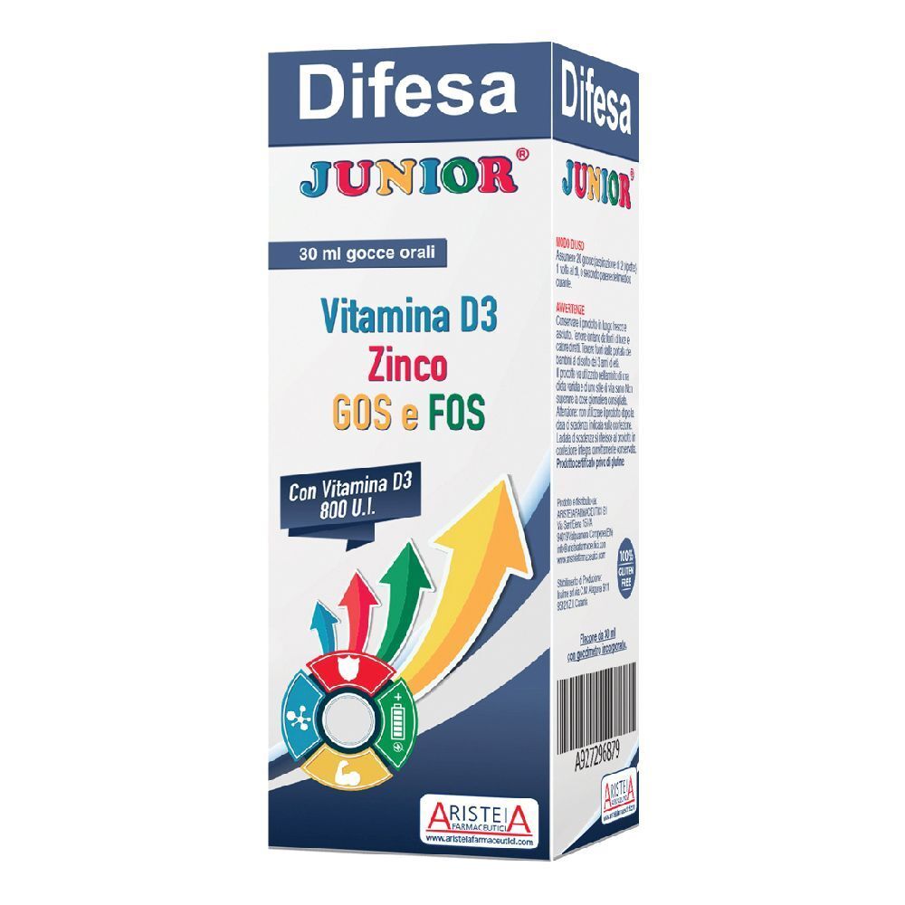 Scatola di Difesa Junior Gocce Orali. Contiene vitamina D3, zinco, GOS e FOS. Con grafica a frecce e logo del marchio.