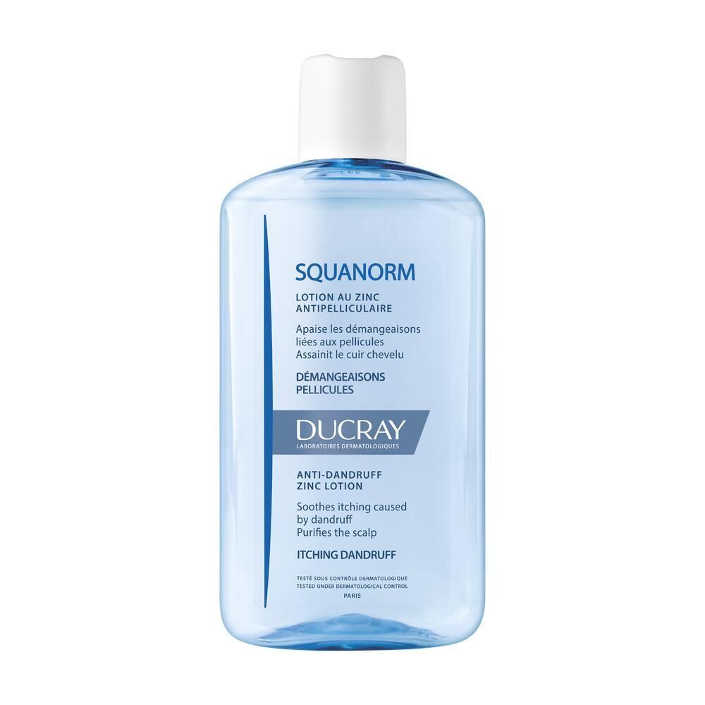Flacon bleu transparent avec bouchon blanc. Inscription : SQUANORM, Lotion au Zinc Antipelliculaire, Ducray.