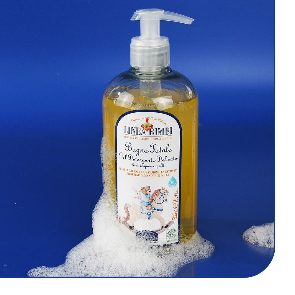 Gelreiniger-Flasche mit Pumpe, umgeben von Schaum. Aufdruck: LINEA BIMBI, Bagno Totale, Gel Detergente Delicato. Kind auf Schaukelpferd.