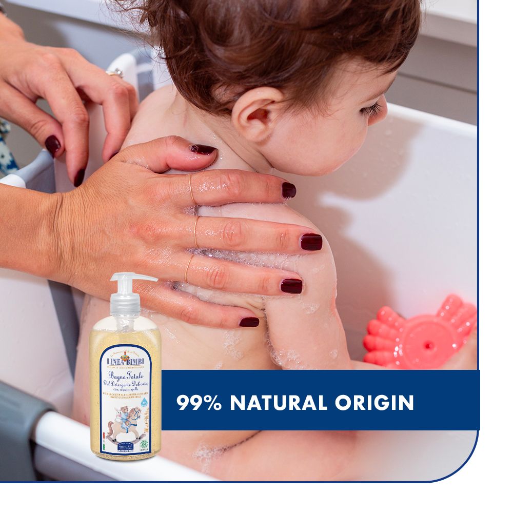 Baby in Badewanne, Mutter wäscht. Flasche: LINEA BIMBI, Bagno Totale. Text: 99% natürlichen Ursprungs.