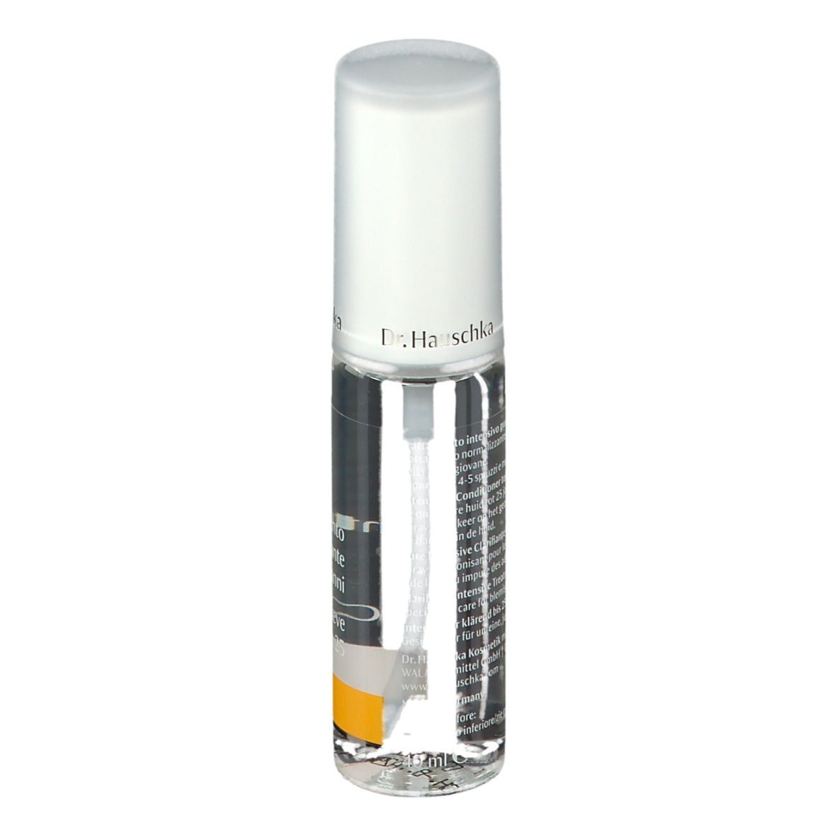 Flacone trasparente con vaporizzatore. Scritta: Dr. Hauschka. Striscia gialla. Etichetta con testo.