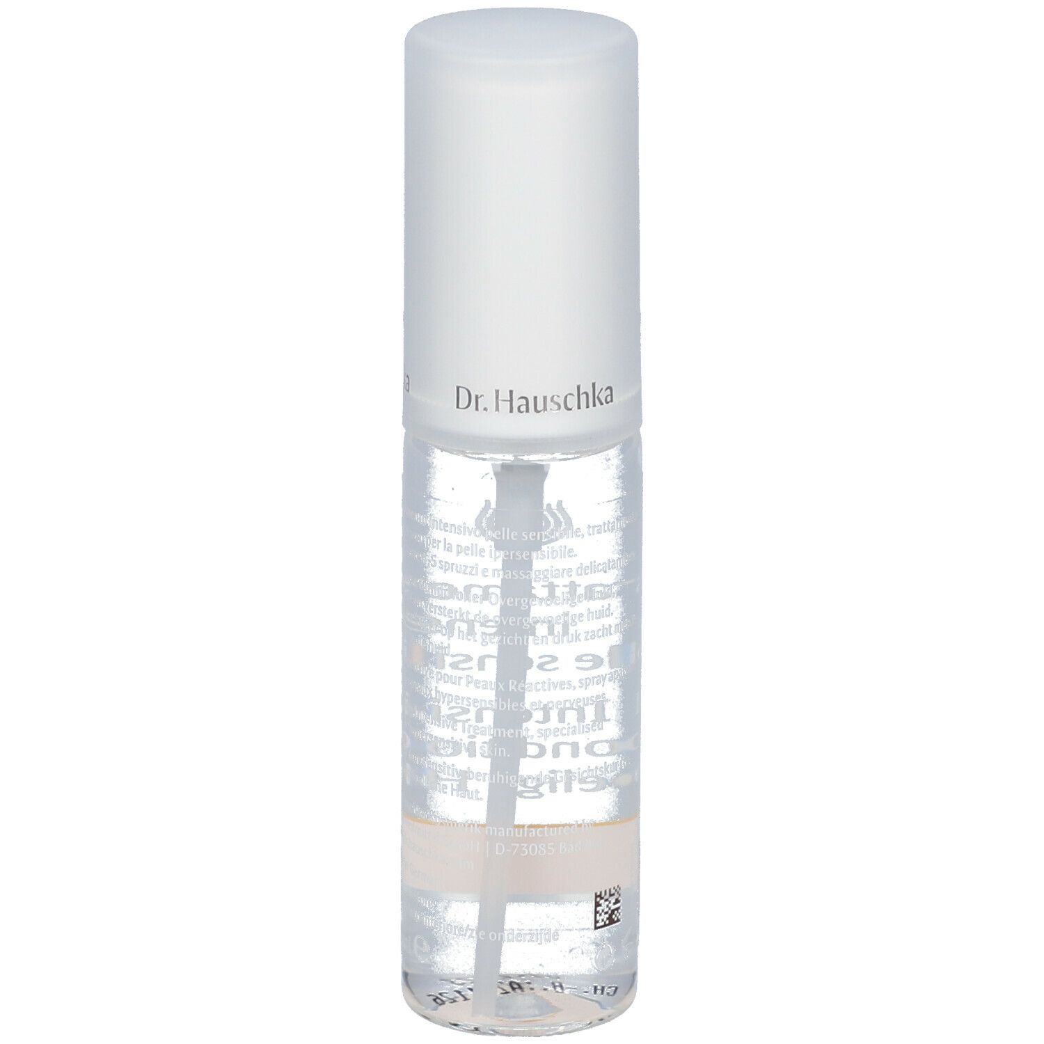 Flacone trasparente con erogatore spray. Scritta: Dr. Hauschka. Etichetta con testo. Striscia gialla in basso.